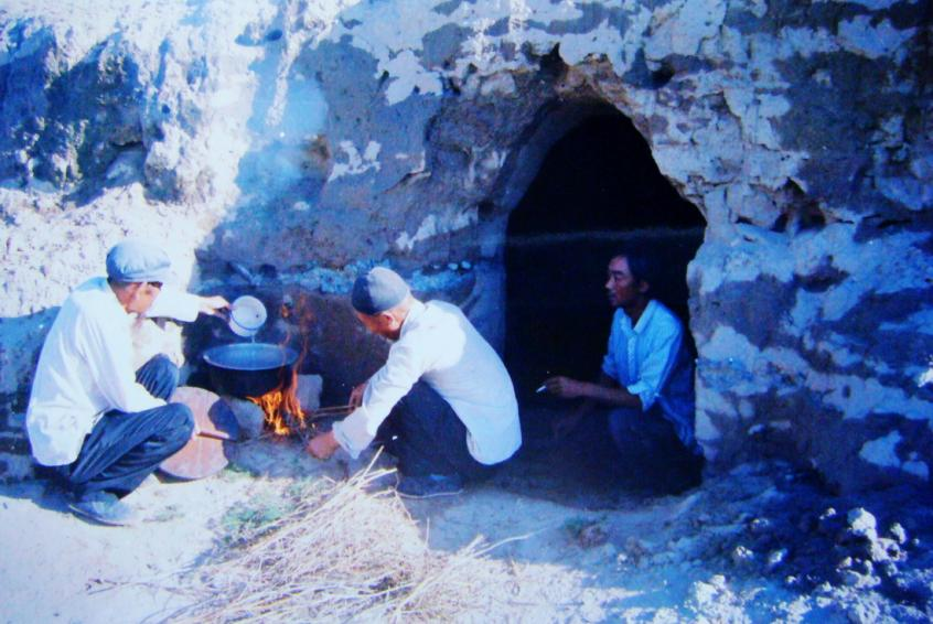 1983年,,“六老漢”一代治沙人在“地窩子”生活做飯,。新華社發(fā)(八步沙林場供圖)