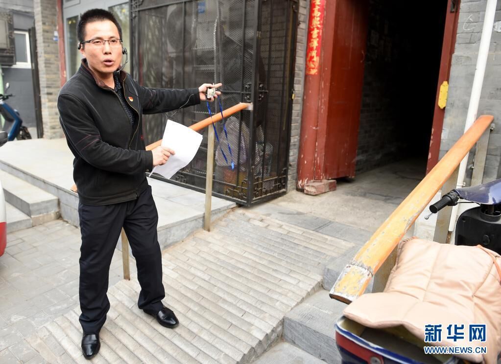 在北京市西城区，街巷长王俊礼在西河沿街218号门前介绍改造坡道、方便院内居民出行情况（2018年4月2日摄）。新华社记者 罗晓光 摄