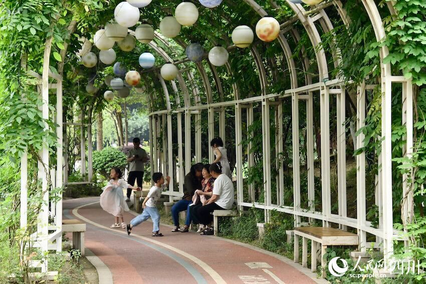 公园内纳凉区域,老人和儿童各得其乐。人民网记者 郭莹摄