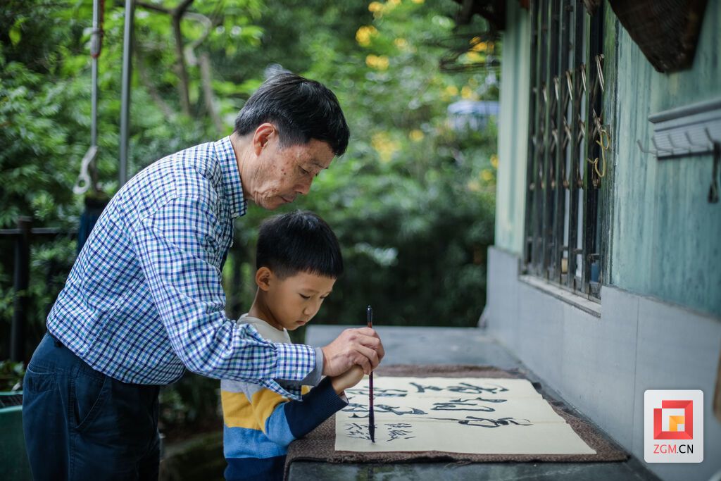 今年69岁的侯绍文老人，退休之后就在家里带外孙，每天都会练书法，有时也带上小外孙一起，享受天伦之乐。（宋姿熠 摄）