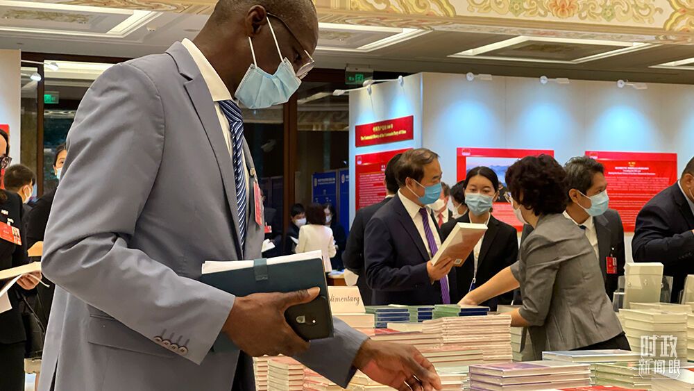 △与会外宾翻阅现场书籍。（总台央视记者卢心雨拍摄）