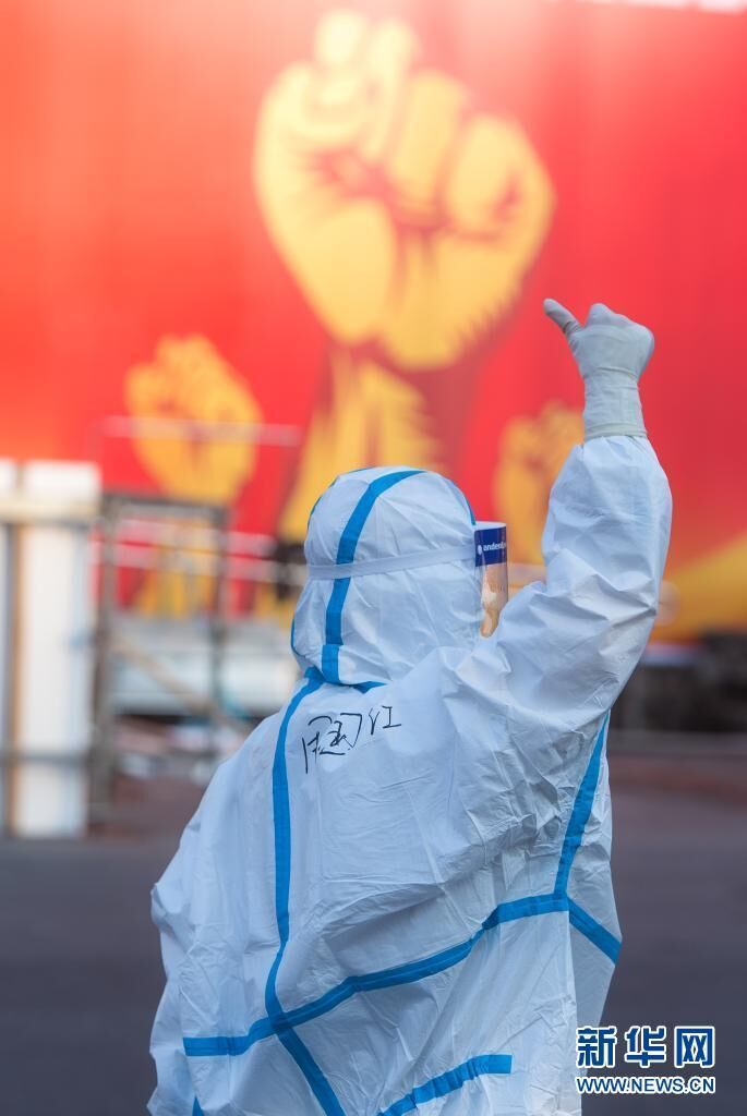 一名医务人员在武汉体育中心方舱医院前竖起拇指为自己和同伴加油鼓劲（2020年2月12日摄）。新华社记者 肖艺九 摄