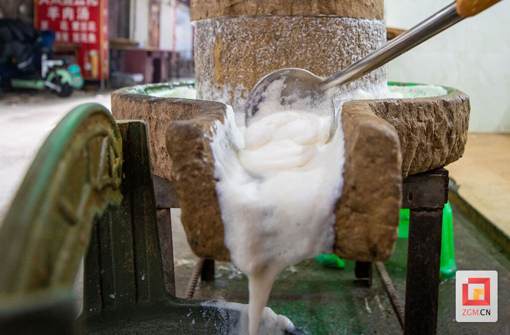 豆浆顺着磨槽淌进桶里 记者 叶卫东 摄.jpg