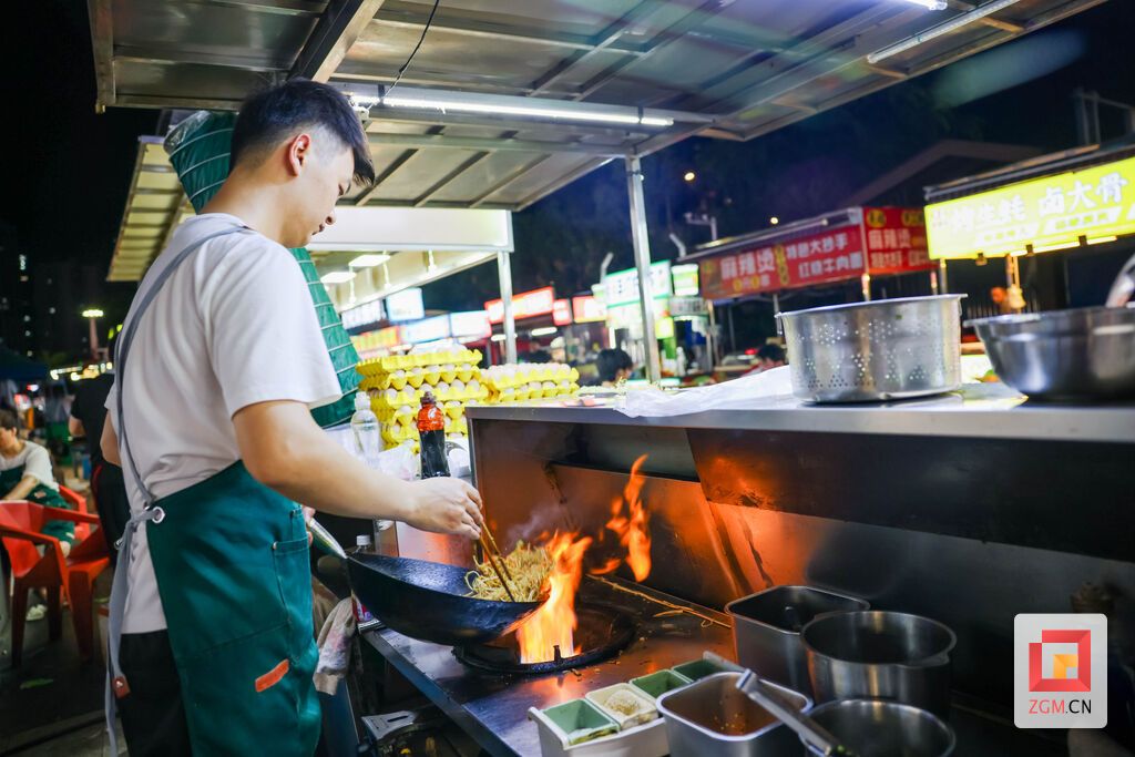 摊主手持锅铲翻炒面食,夜市街头锅气十足,满是地道市井美味。 记者 宋姿熠 摄.jpg