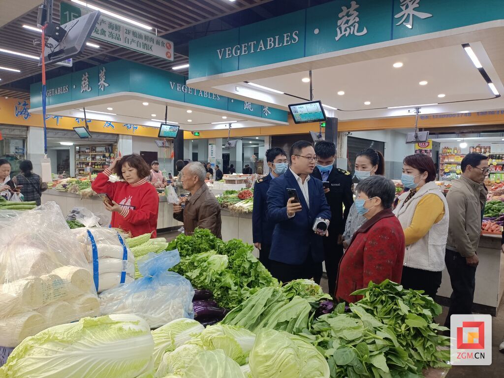 “街坊團(tuán)”在蔬菜區(qū)域，了解攤位上的收款方式。