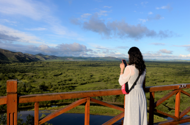 日落时分，湿地公园景色壮美，游客在拍摄照片。（中国日报网 赵诗悦/摄）