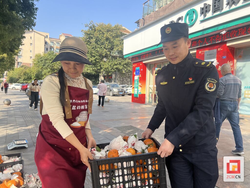 城管队员正在帮商户搬货 记者 陈行 摄.jpg