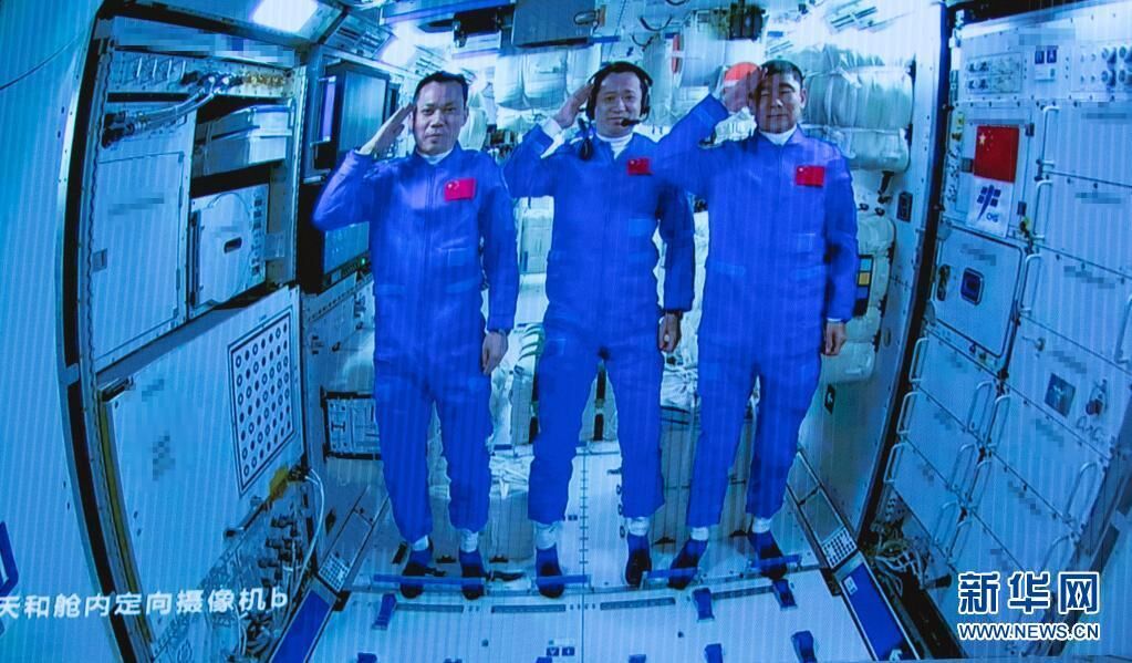 这是2021年6月17日在北京航天飞行控制中心拍摄的进驻天和核心舱的航天员向全国人民敬礼致意的画面。新华社记者 金立旺 摄