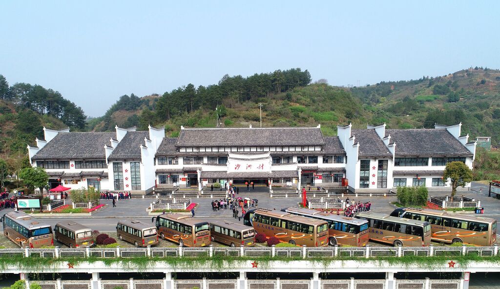 沙洲村游客服务中心前停满大巴车，天南地北的游客慕名而来。郴州日报摄影记者 曹高林 摄