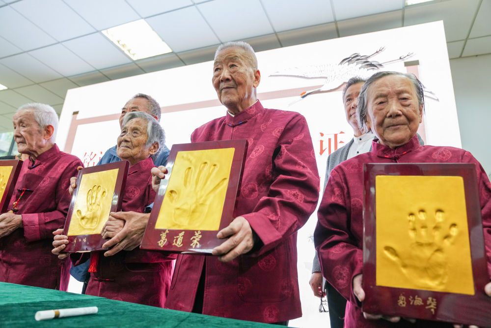 2022年10月4日，南京大屠杀幸存者夏淑琴、葛道荣、薛玉娟和王义隆（前排，从右到左）在侵华日军南京大屠杀遇难同胞纪念馆举办的重阳节活动上展示手印。新华社记者 李博 摄.jpg