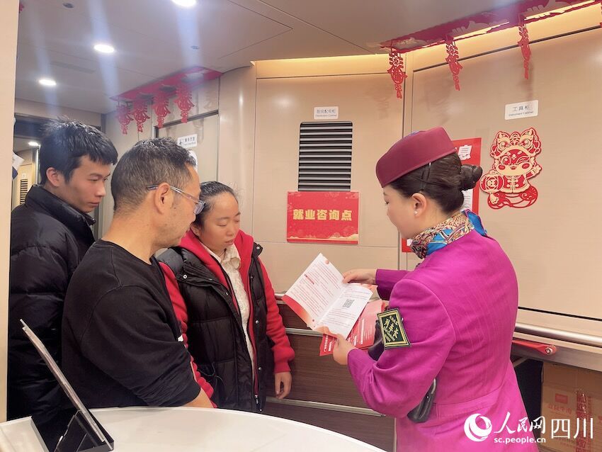 列車工作人員為旅客介紹招工信息。王明月攝