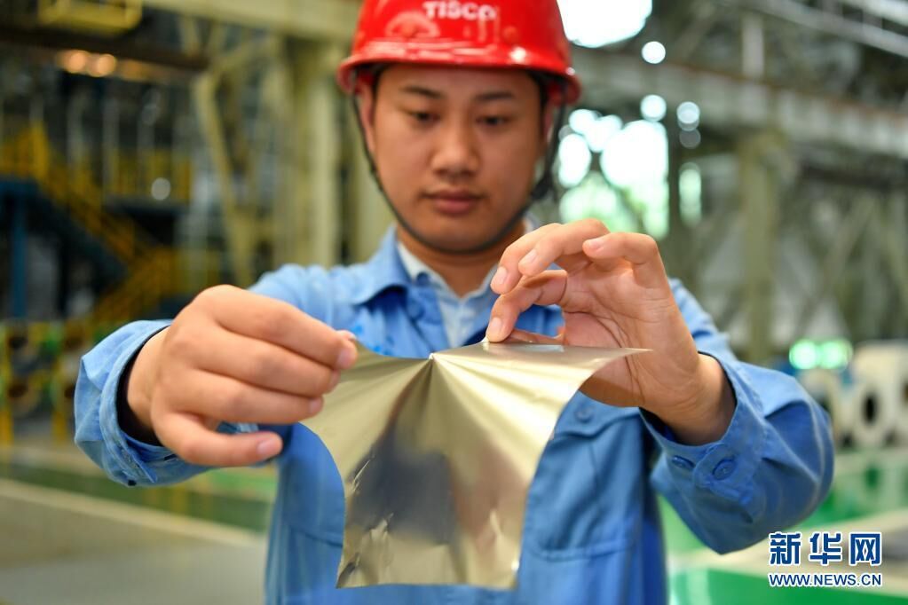 太钢集团员工在展示用手撕开0.02毫米厚的超薄带状不锈钢（2019年5月24日摄）。新华社记者 曹阳 摄