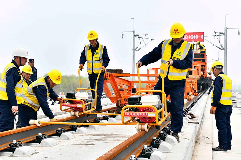 3月15日，在日兰高铁山东嘉祥县段，中铁一局的工作人员进行铺轨作业。新华社记者 郭绪雷 摄