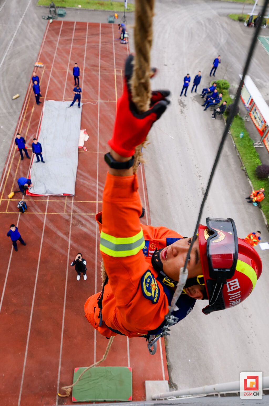 消防员演练徒手攀爬绳索上四楼。