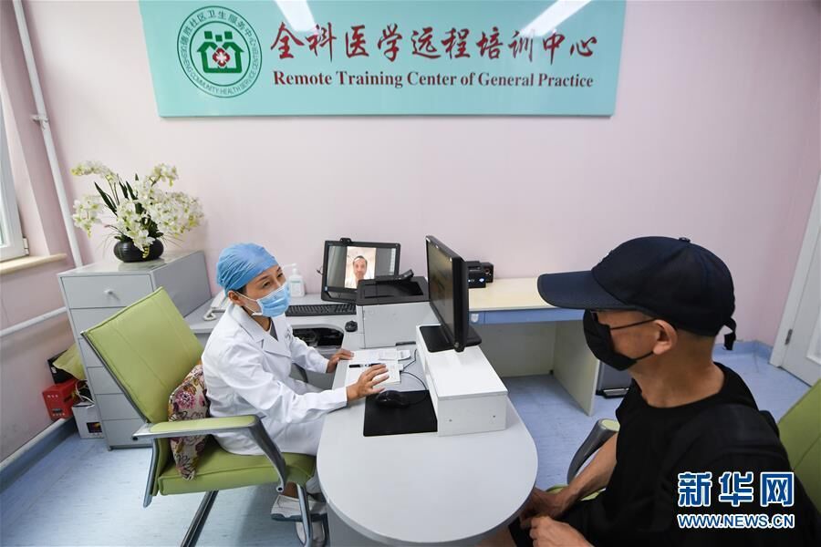 在北京市西城区德胜社区卫生服务中心，家庭医生谢妍（左）通过远程视频与北大第一医院急诊科医生汪波交流，为居民周自仲问诊（2020年8月17日摄）。 新华社记者 鞠焕宗 摄