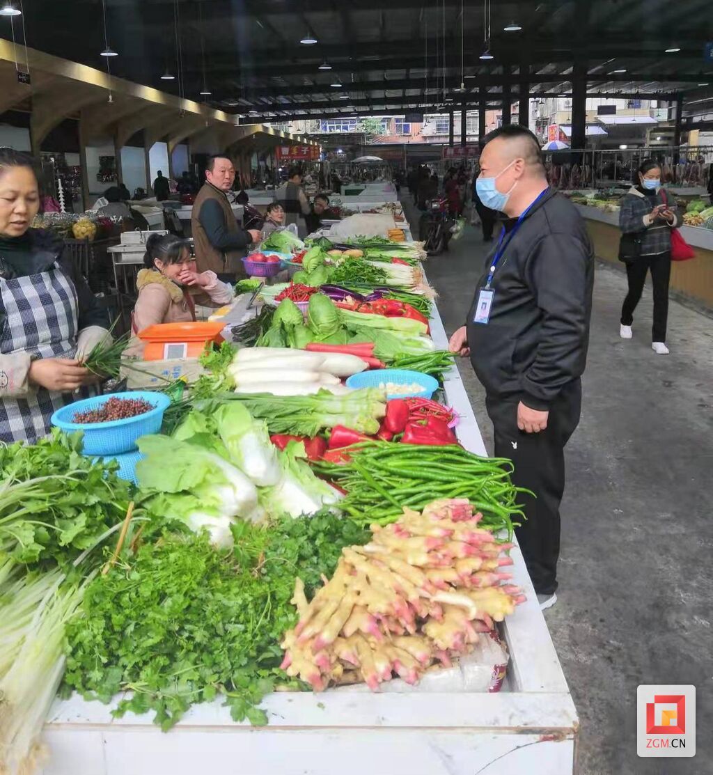 图：市场管理工作人员向经营户宣传规范、了解需求。