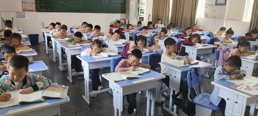 白衣小學學生使用受捐贈課桌椅.jpg