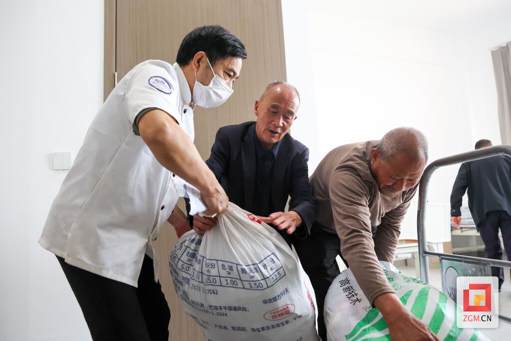 中心工作人员协助老人搬运行李.JPG