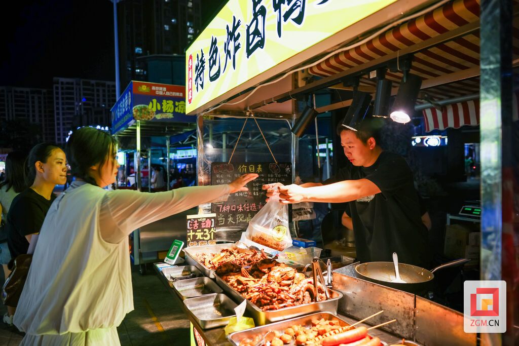 摊主递出卤味小吃,夜市摊位烟火氤氲,尽显自贡夜间消费热闹景象 记者 宋姿熠 摄.jpg