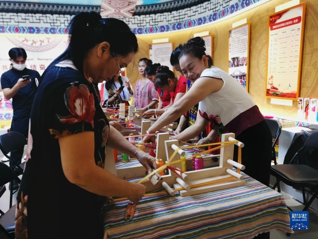 在广西南宁市青秀区凤岭北社区民族之家，社区居民在用简易织机制作壮锦（2020年7月21日摄）。新华社记者 黄庆刚 摄