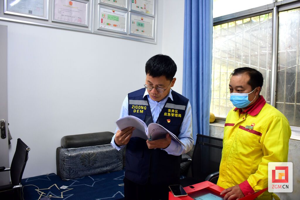 李兵（图左）检查企业应急救援预案及演练情况