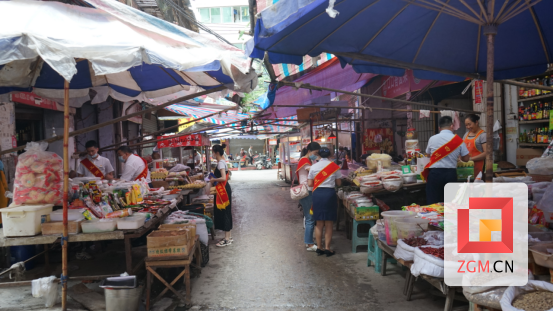 图为：银行工作人员深入北街菜市为商户开展纸硬币收兑服务