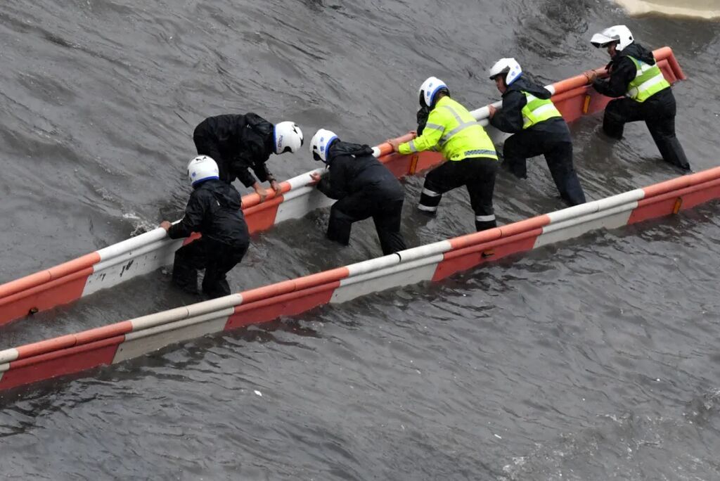 7月20日，交通警察在郑州市花园路冒雨修复交通设施。新华社记者 朱祥 摄