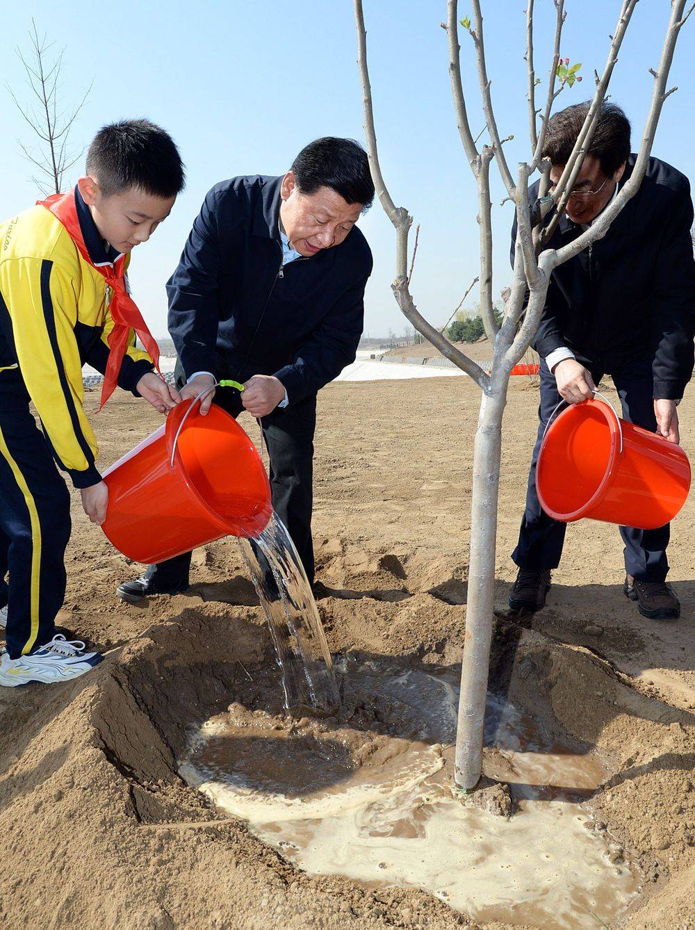 ↑2014年4月4日，党和国家领导人来到北京市海淀区南水北调团城湖调节池参加首都义务植树活动。这是习近平同大家一起给刚栽下的树苗浇水。植树结束时，习近平向工程负责人了解了南水北调水源的水质与保护和调节池施工进展情况。