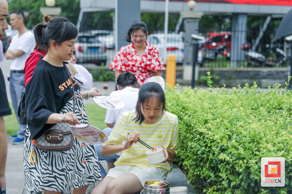 自貢蜀光中學(xué)考點(diǎn)，結(jié)束完7日上午的考試，校門口，考生在家長的陪伴下吃午飯