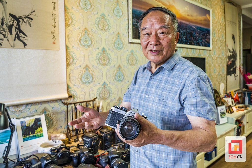 邓佑云拿着尼康FM2向记者讲述相机背后的故事(周馨钰 摄).jpg