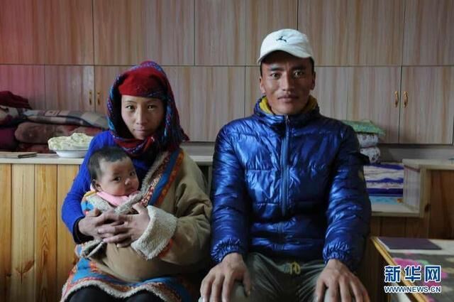 在青海省黄南藏族自治州尖扎县尖扎滩乡萨尕尼哈易地扶贫搬迁安置点，村民李加才让与妻子尚周玛、女儿曲珍措在家中合影（2020年12月17日摄）。新华社记者 顾玲 摄