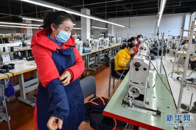 山西省岚县脱贫户刘志平（左一）在位于岚县易居苑社区的扶贫工厂内准备工作（1月8日摄）。新华社记者 曹阳 摄