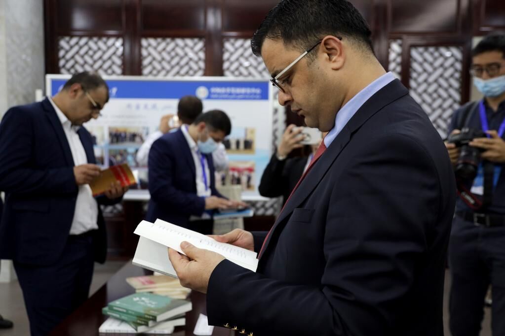 伊拉克驻华大使馆一秘马德胡尔翻阅阿文版《以习近平同志为核心的党中央治国理政新理念新思想新战略》。