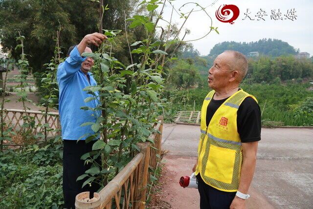 八甲村1组01院落院长朱德贵与困难邻居攀谈(黄明鑫 摄)