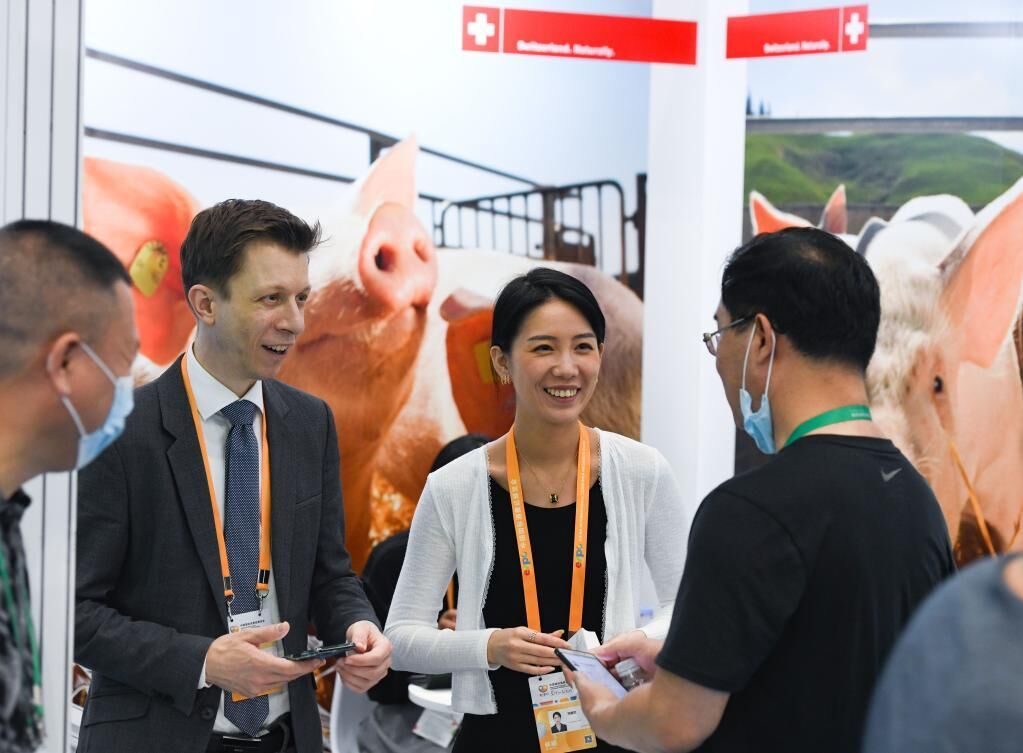 5月8日，消博会参展工作人员微笑着与观众沟通